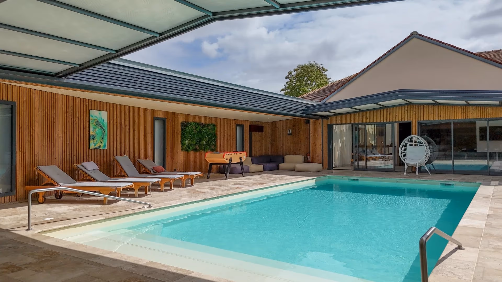 Piscine intérieure couverte avec verrière et espace lounge
