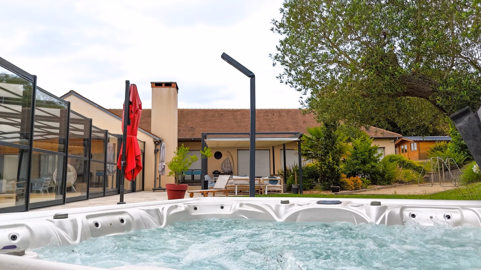 Bain à remous extérieur avec vue sur la villa et le jardin